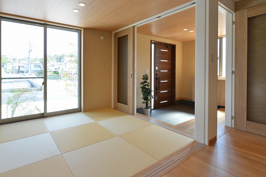 玄関と和室は引き戸を開け放して一体化して利用できます。天井の高さを揃え、スッキリと見せる工夫も。