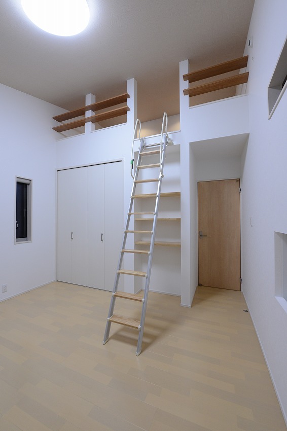 洋室は勾配天井を活かしてロフトを設計。下部はクロゼットや飾り棚、本棚を造作し、収納力も十分です。
